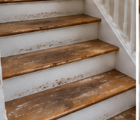 Illustrative before view of worn wooden stair treads and chipped white risers